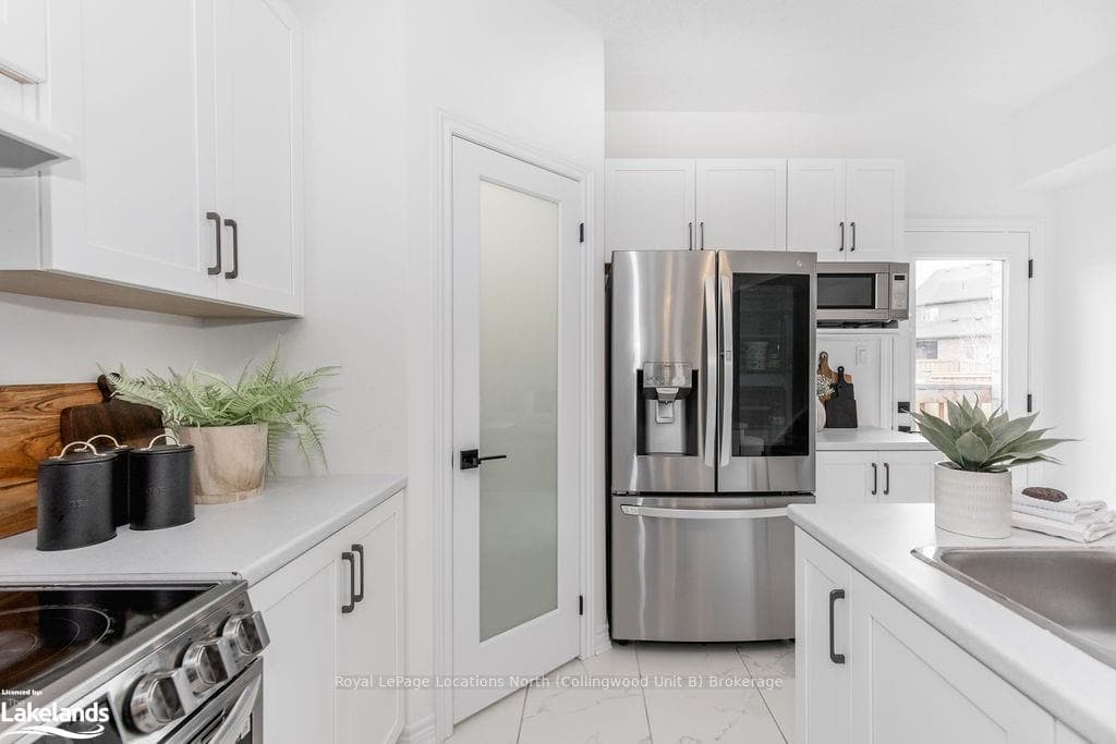 Kitchen featuring white cabinetry and stainless st