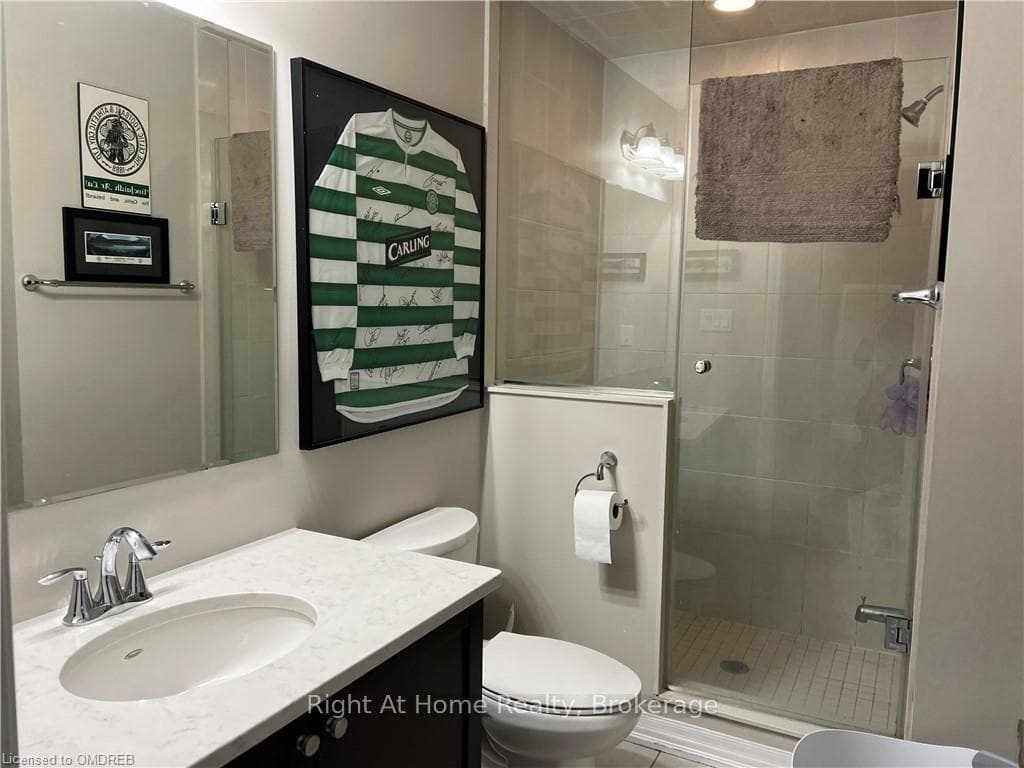 Bathroom with vanity, toilet, and an enclosed show