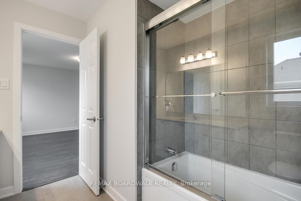 Ensuite washroom with tiled bath tub & glass doors