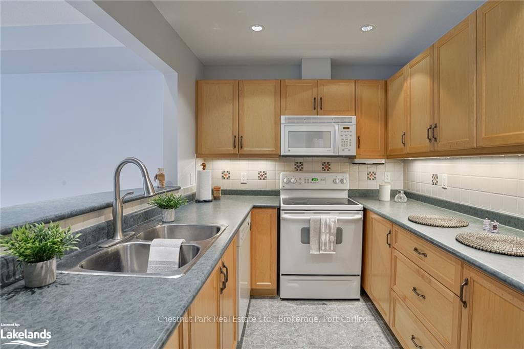 Kitchen with decorative backsplash, double sink, a