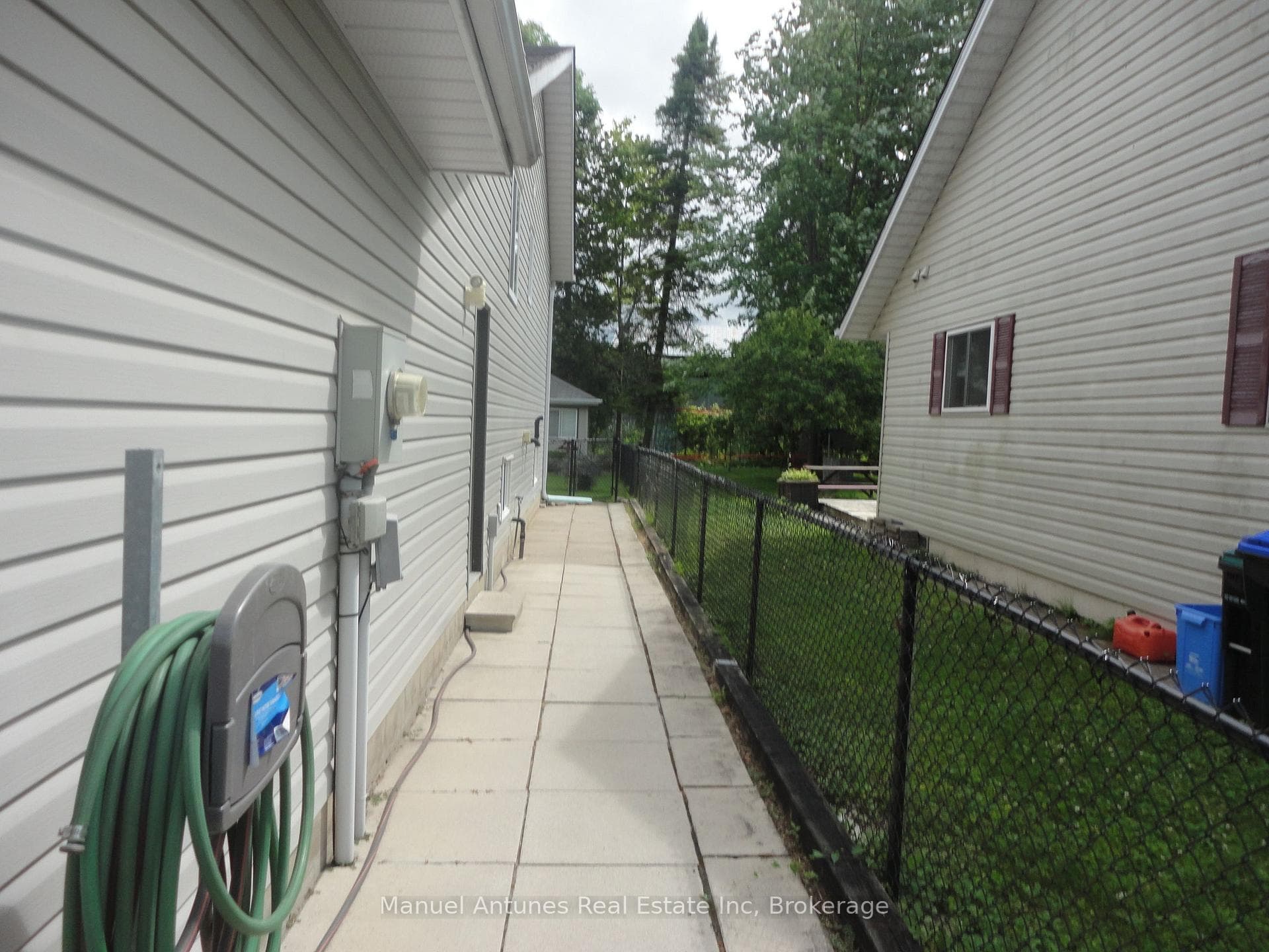 Looking between houses to fully fenced rear yard
