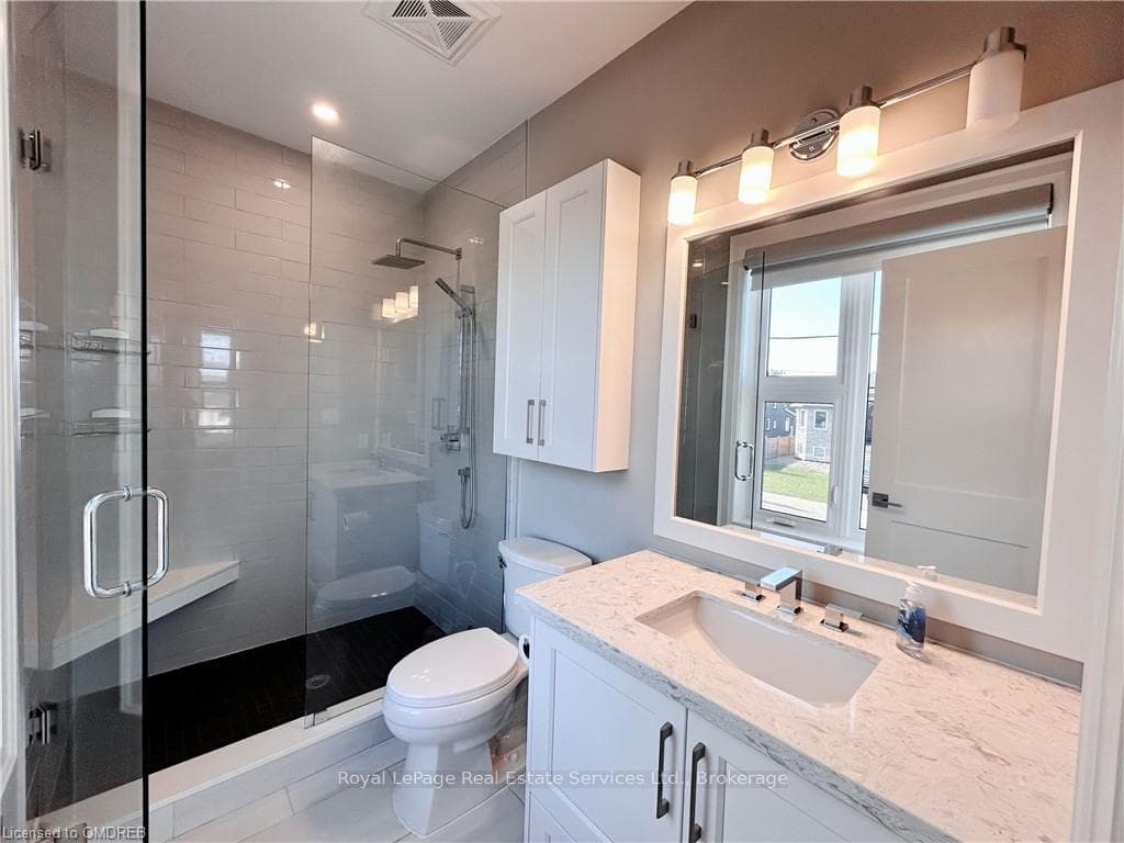 Bathroom featuring tile flooring, vanity, toilet,