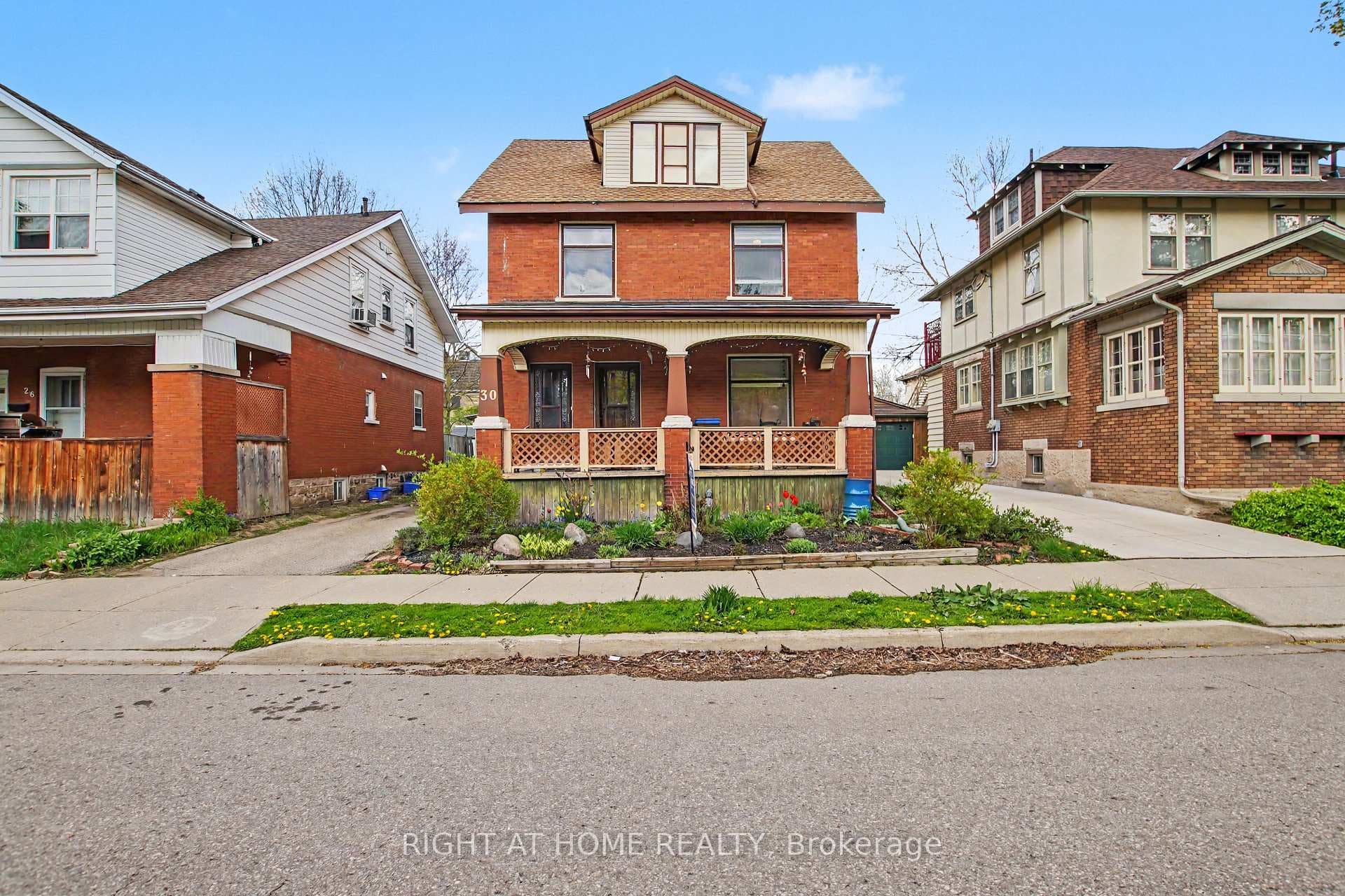 Red brick covered front porch front garden bed