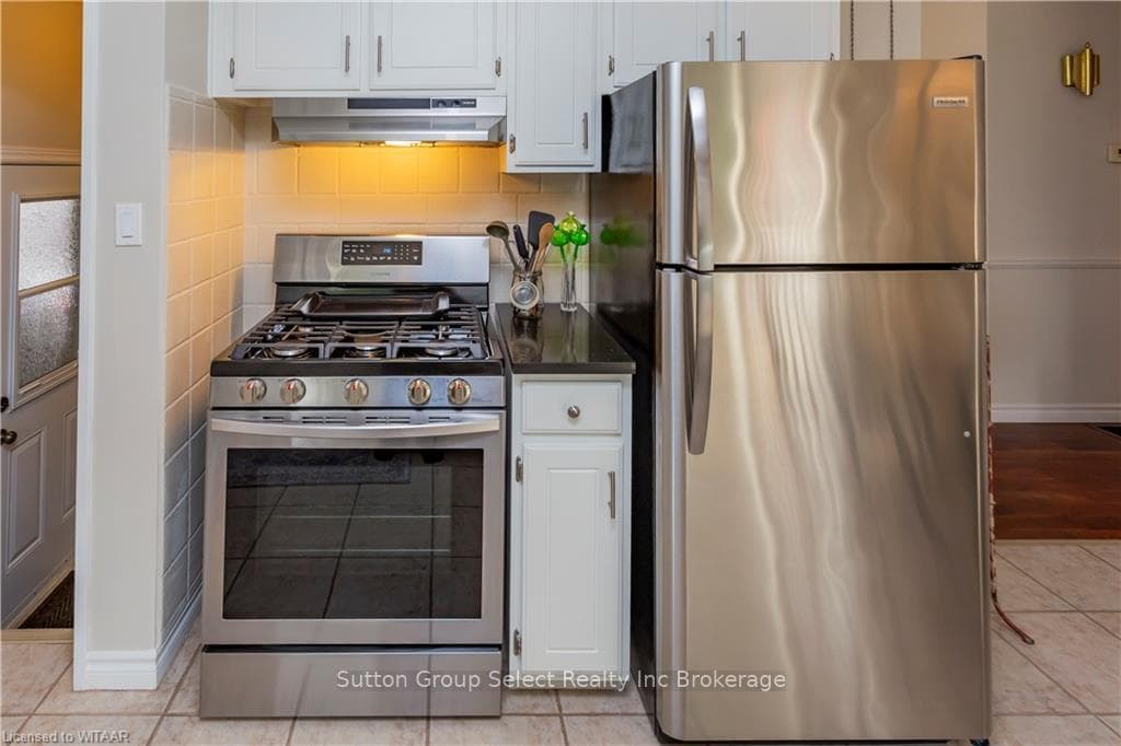 Kitchen with light tile patterned flooring, white