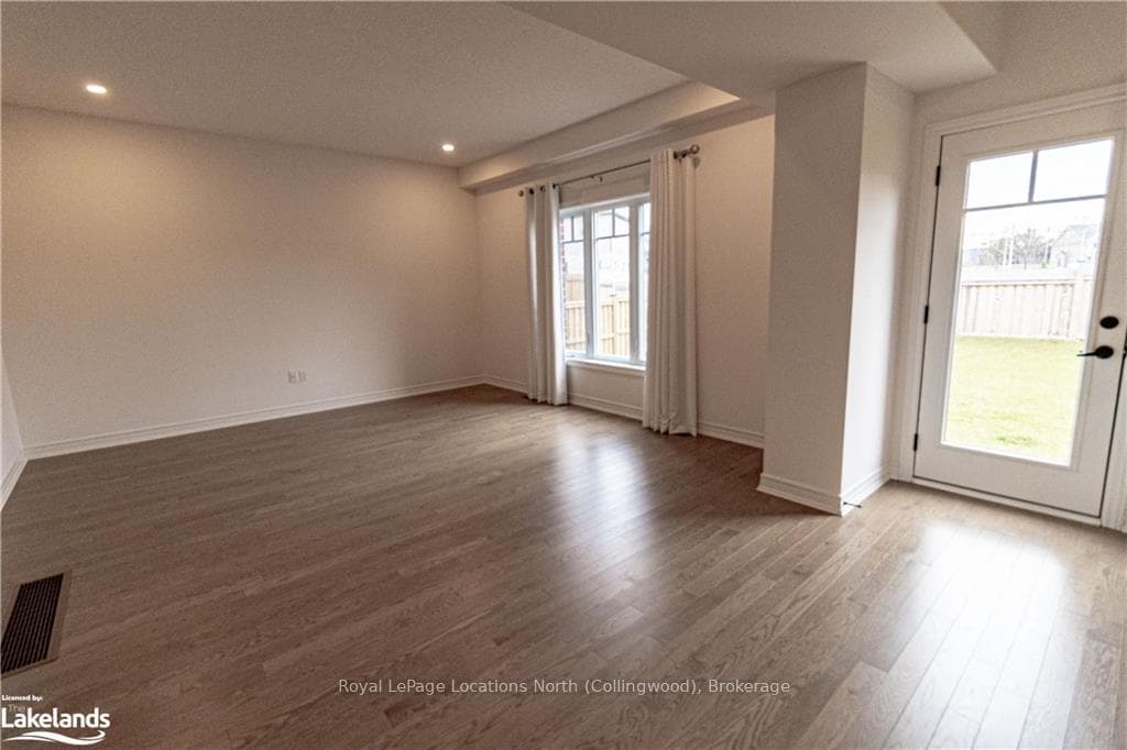 Spare room featuring wood-type flooring and a heal