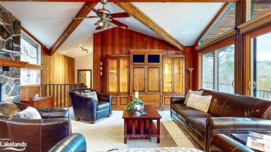 Living room featuring beamed ceiling, ceiling fan,