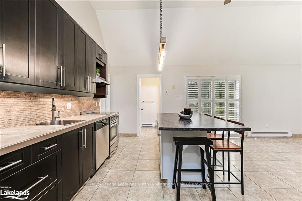 Kitchen featuring a kitchen bar, hanging light fix