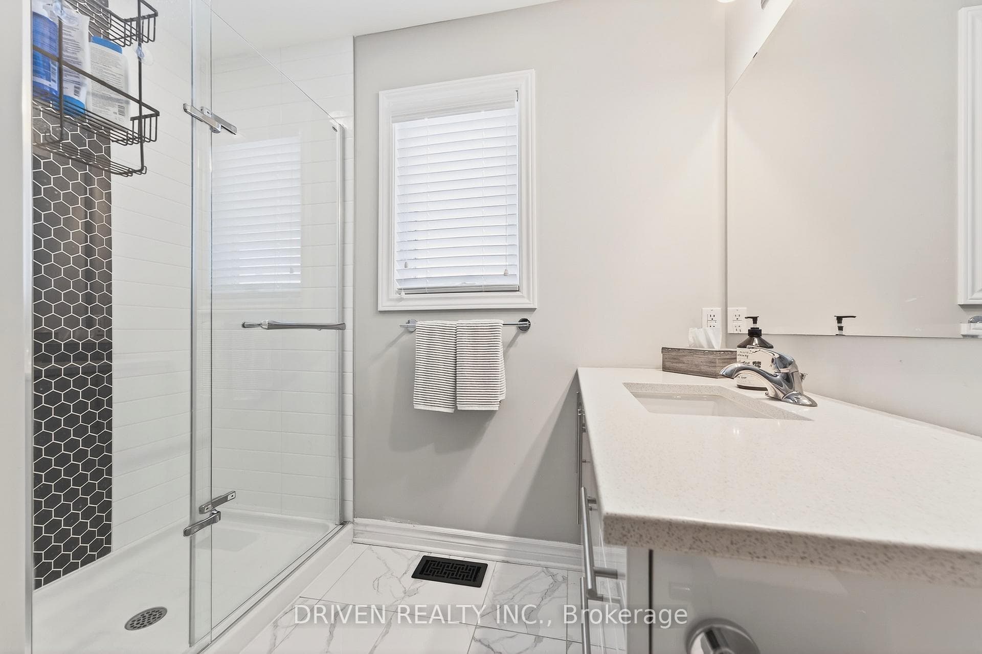 Sleek glass shower with modern tile accents.