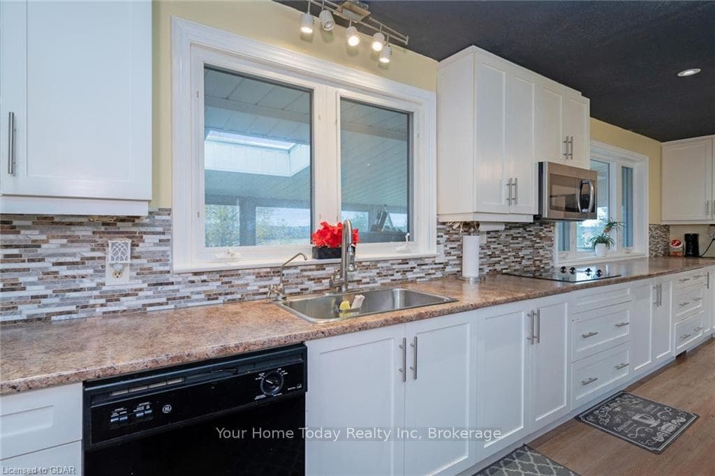 Kitchen featuring black appliances, white cabinets