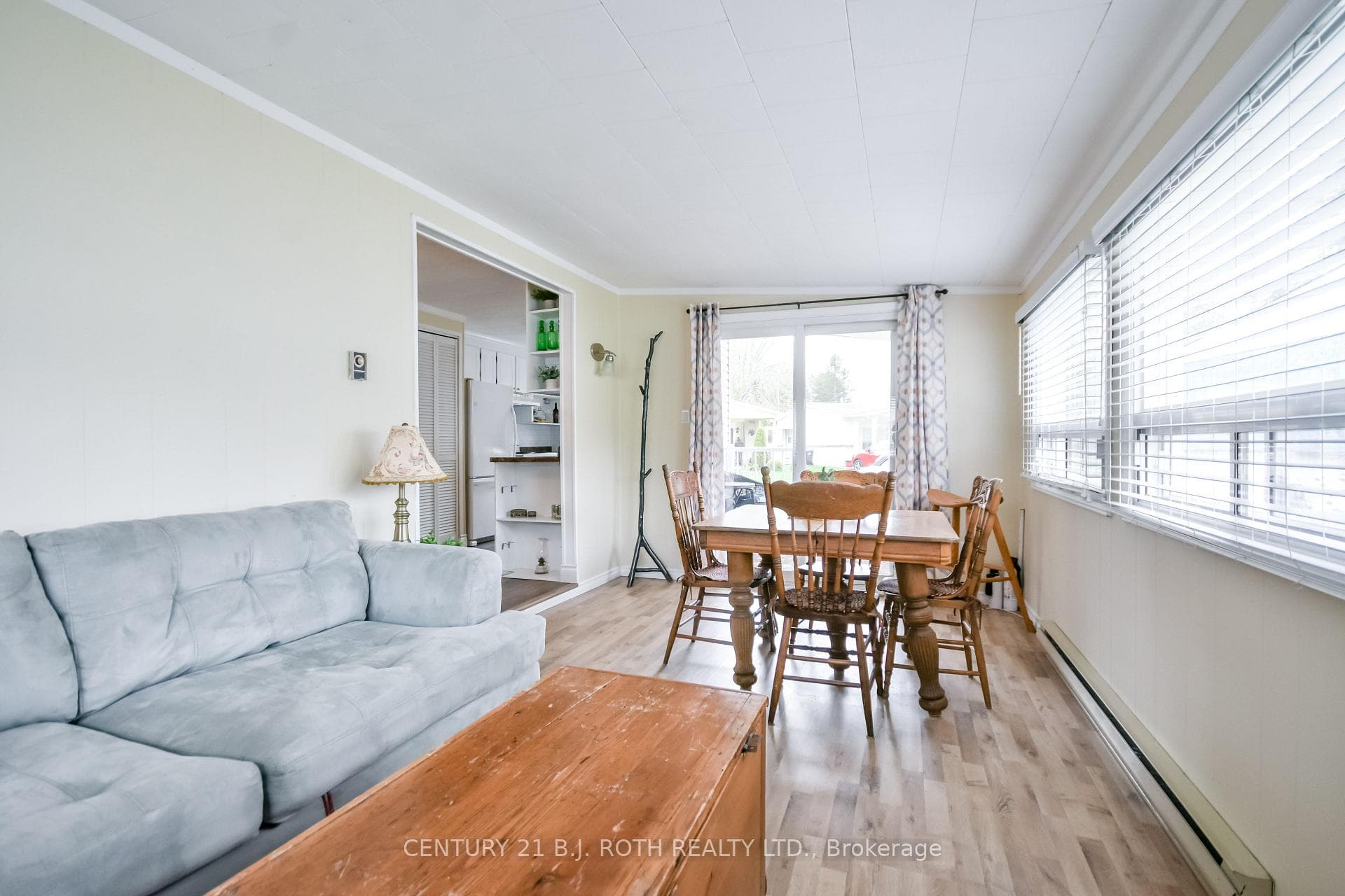 Sun drenched sun room with laminate floors.