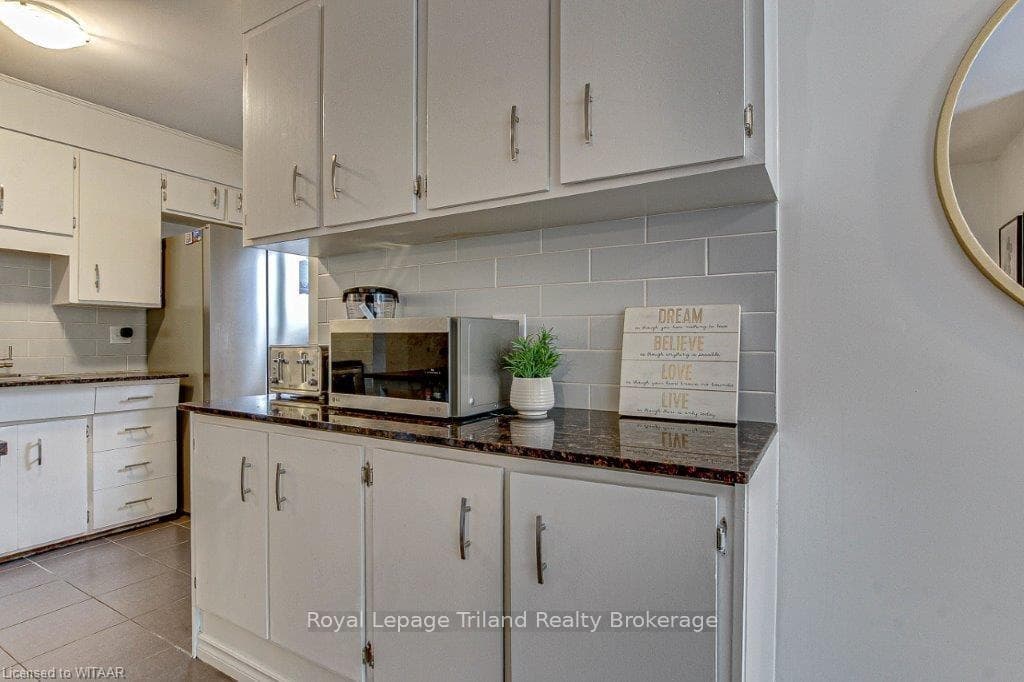 Kitchen featuring dark stone countertops, white ca