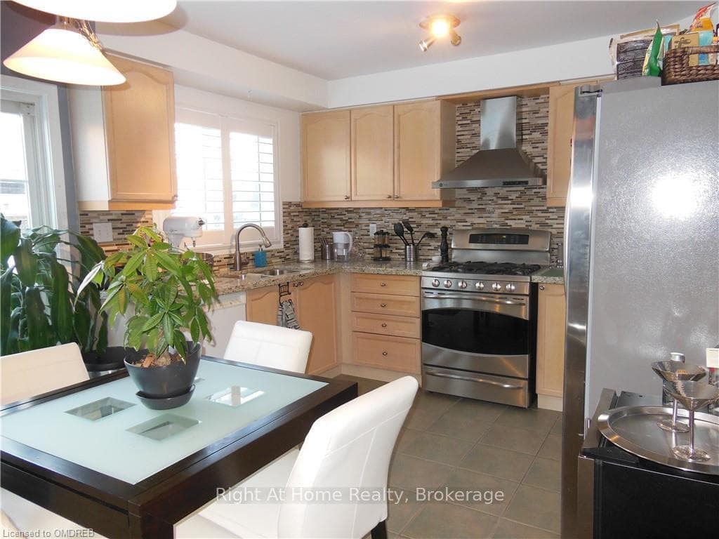 Kitchen featuring backsplash, appliances with stai