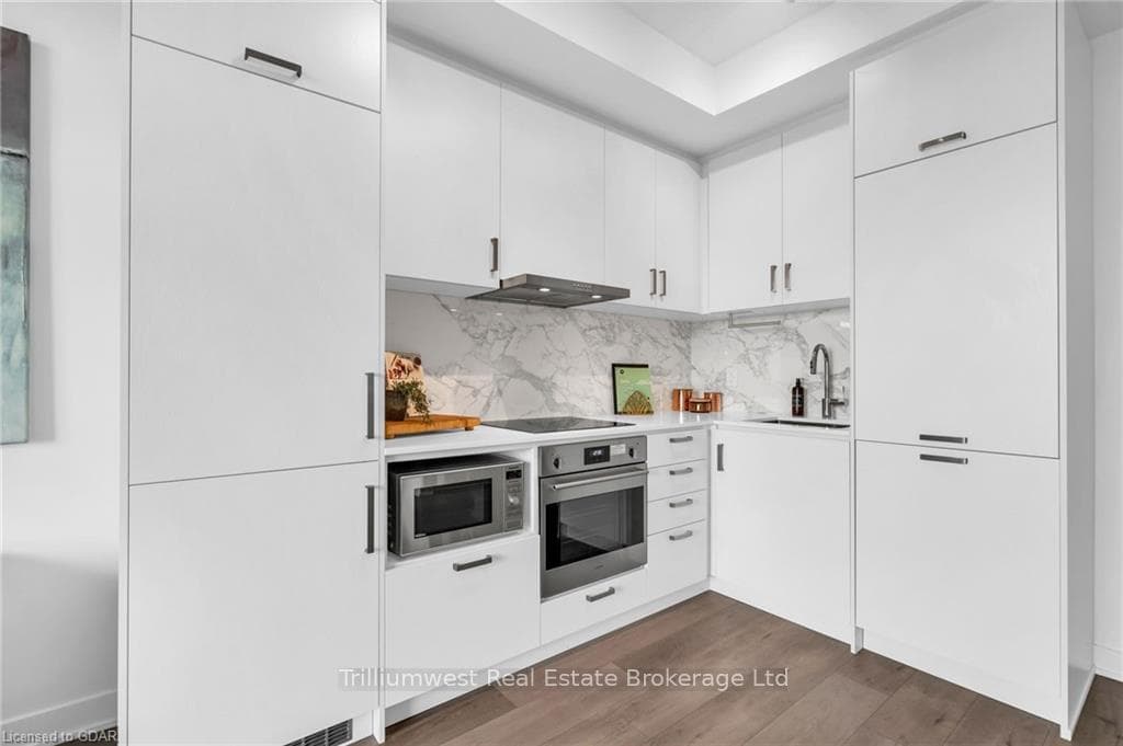 Kitchen with hardwood / wood-style flooring, built
