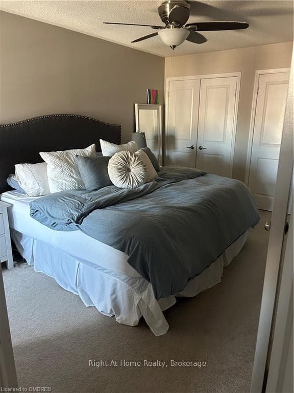 Carpeted bedroom with a textured ceiling and ceili