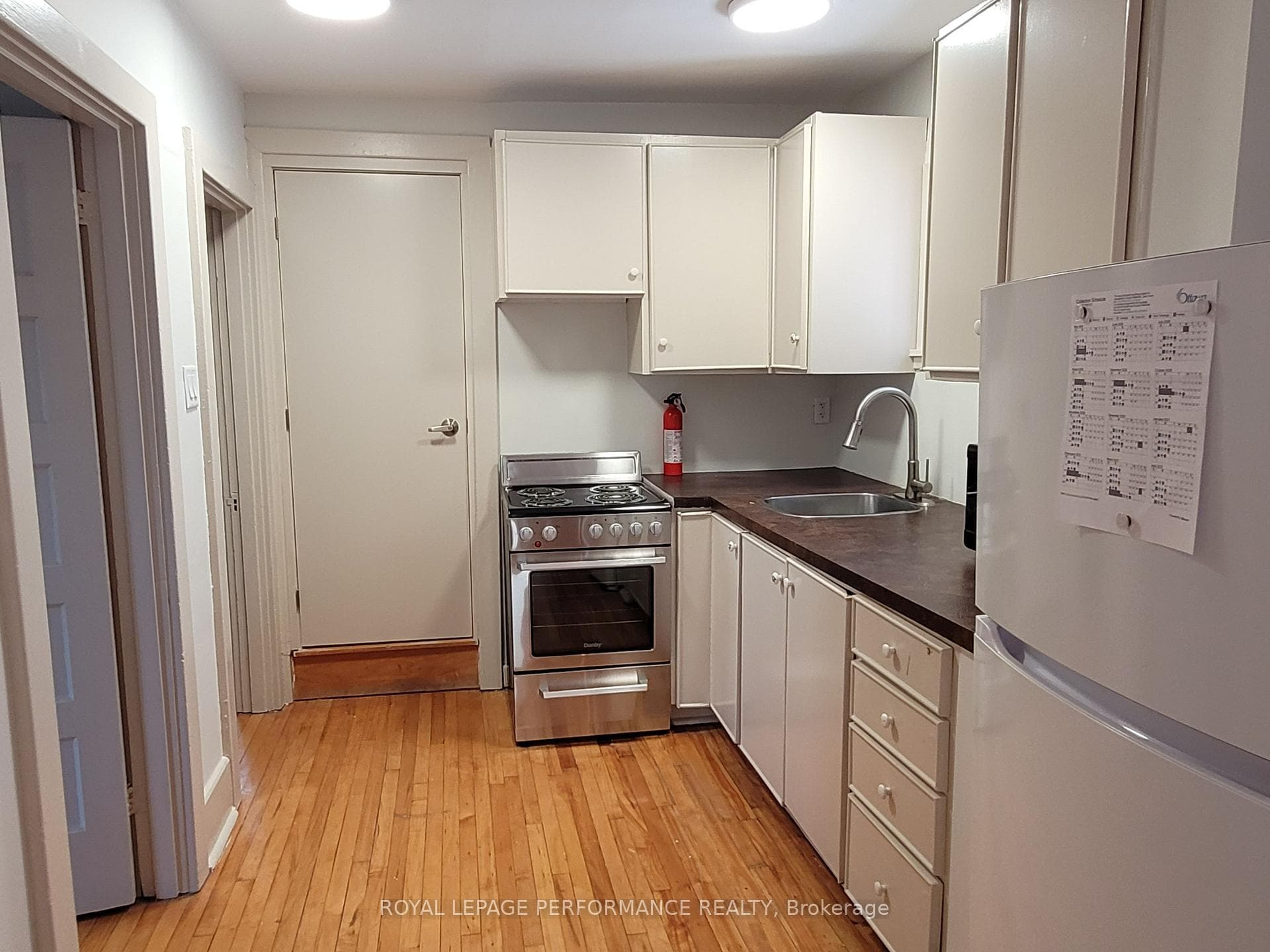 Kitchen with new stove; bathroom door at end