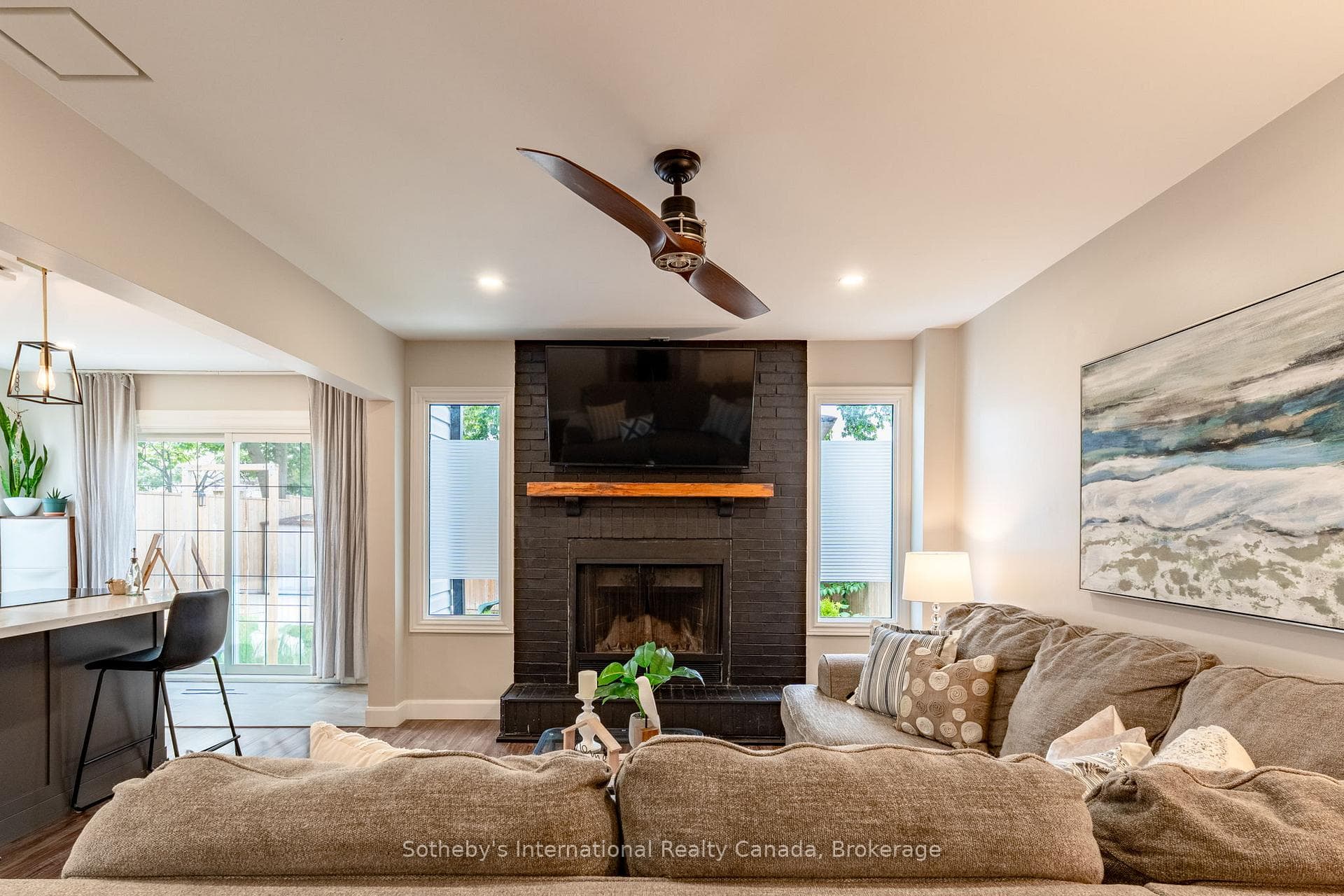 Living room with wood fireplace, open to kitchen.