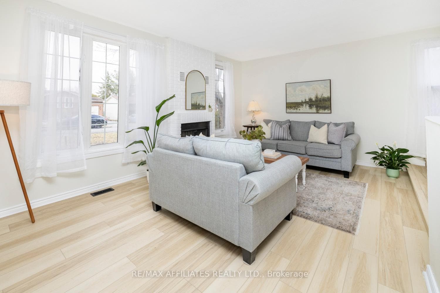 Large cozy living room grounded by wood fireplace