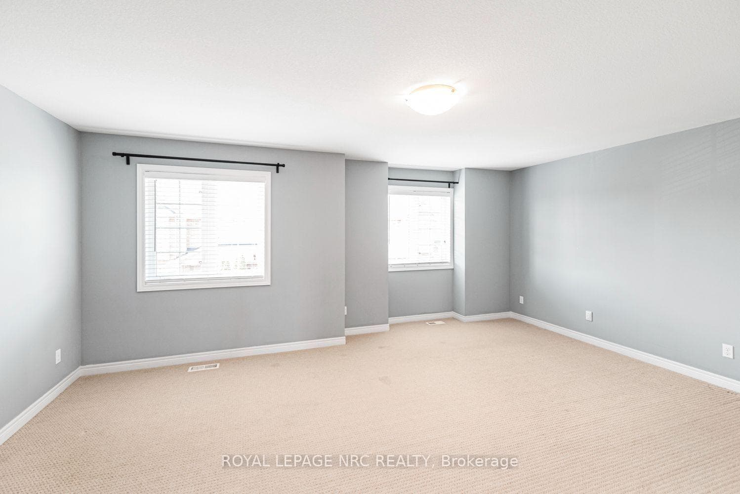 Expansive primary bedroom with 2 large windows