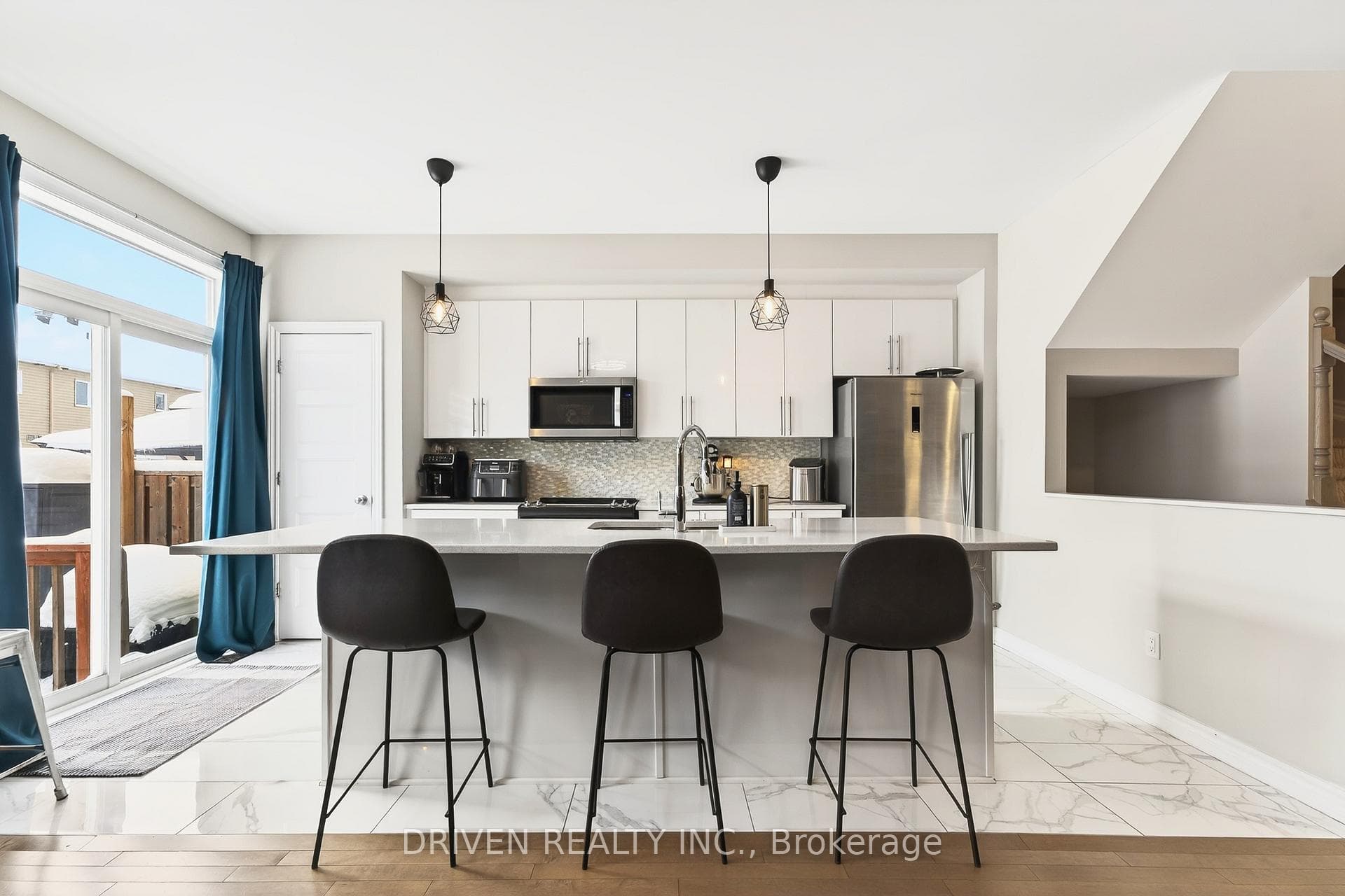 Bright, modern kitchen featuring stone counters.