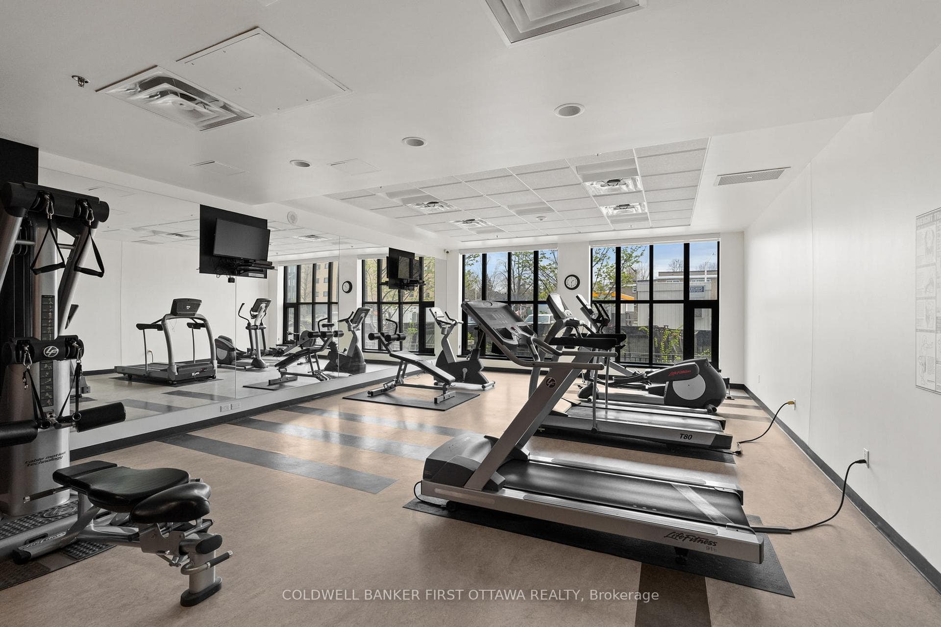 Main lvl full fitness room w natural light & TVs.