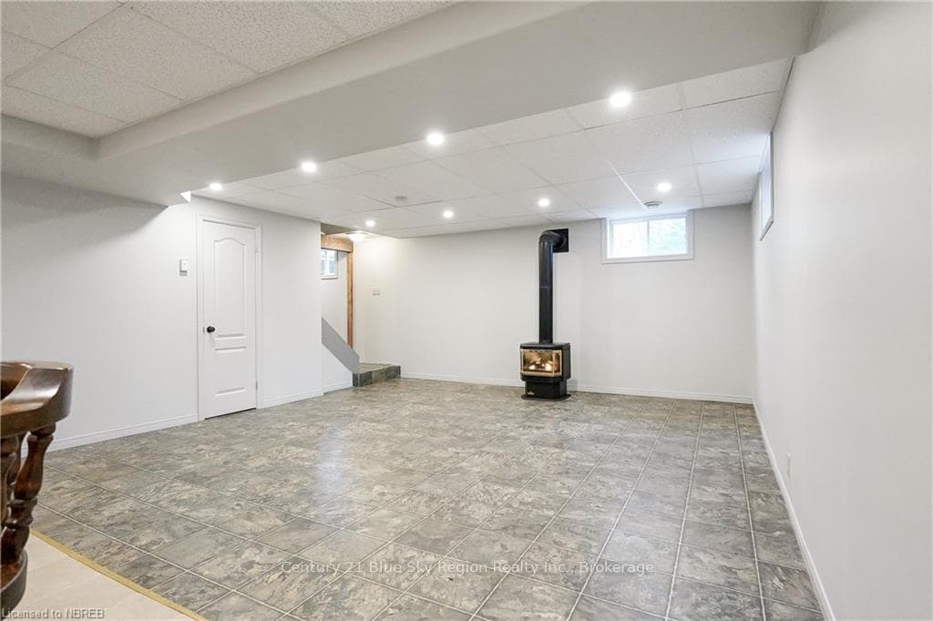 Basement with a drop ceiling and a propane stove