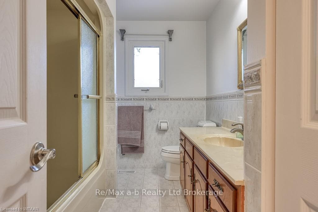 Full bathroom with combined bath / shower with gla