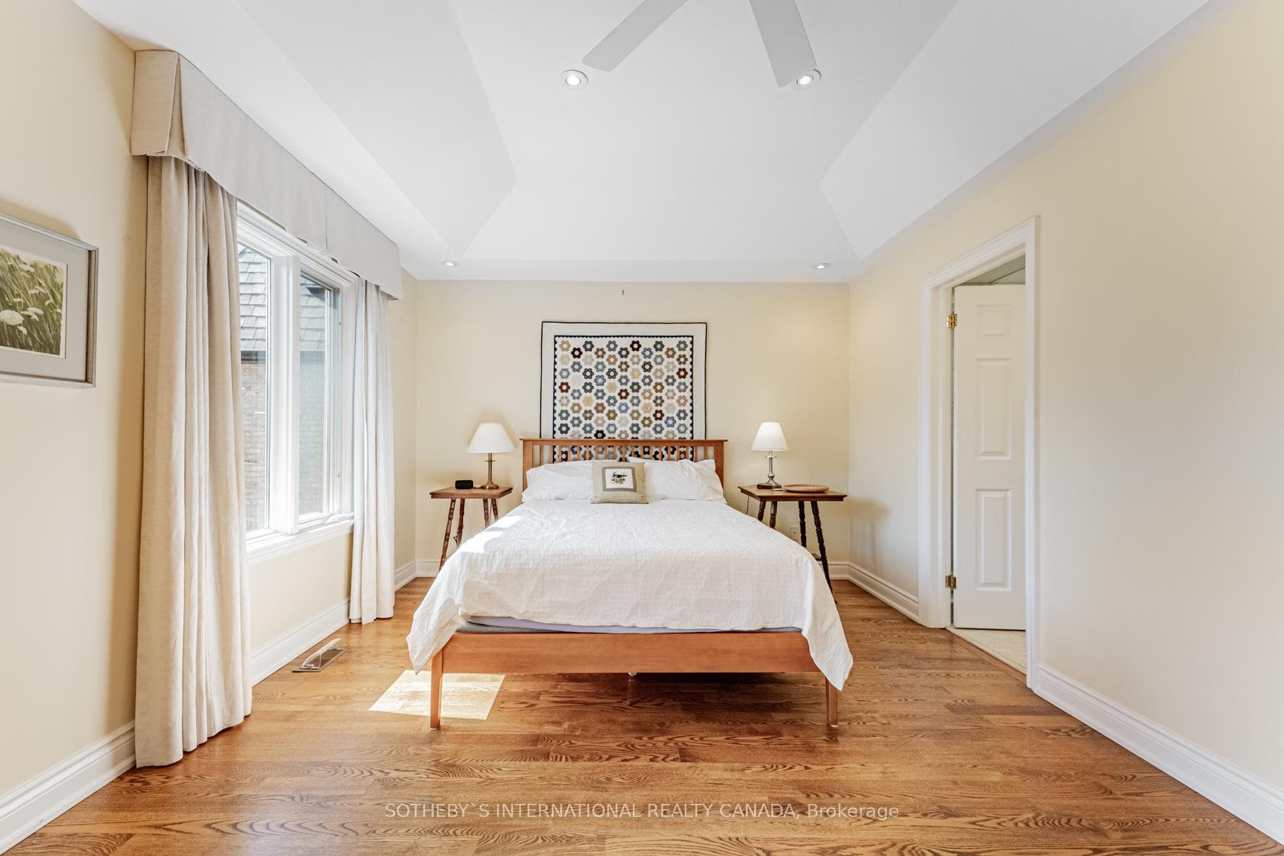 Primary bedroom with coffered ceiling & balcony.
