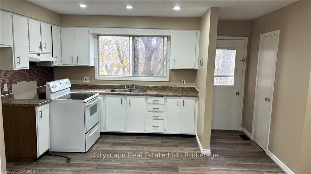 Kitchen with white cabinetry, white range with ele