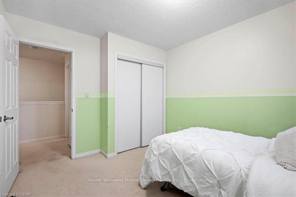 Carpeted bedroom featuring a textured ceiling and