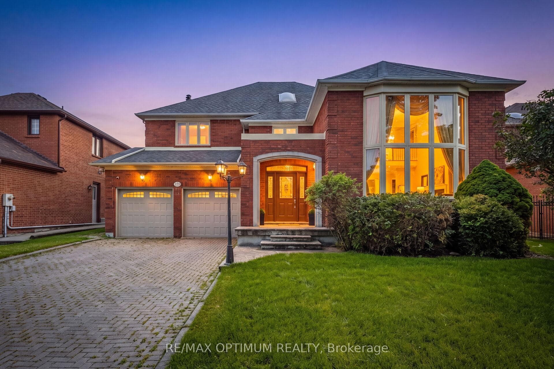 Grand curb appeal with double garage at dusk