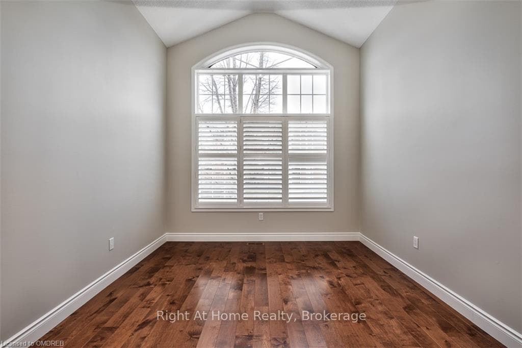 Empty room with dark wood-type flooring and lofted