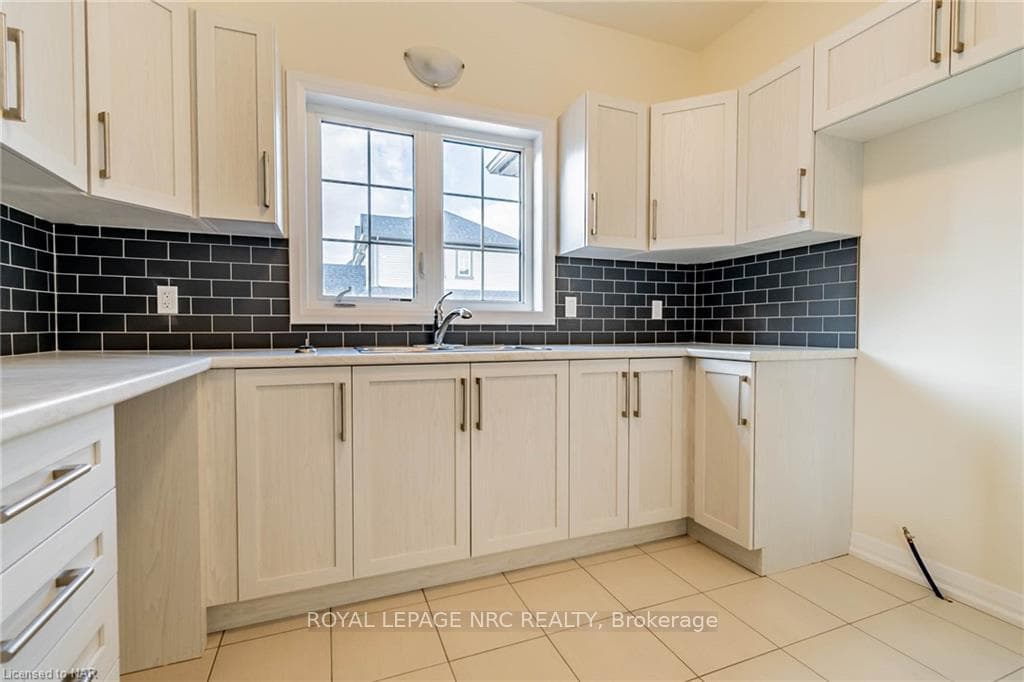 Kitchen featuring sink, decorative backsplash, and