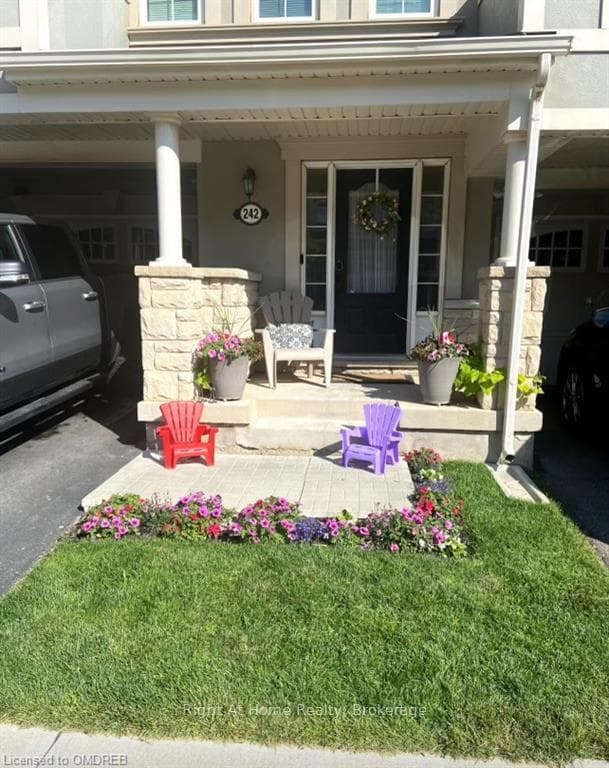 Doorway to property with a yard and covered porch