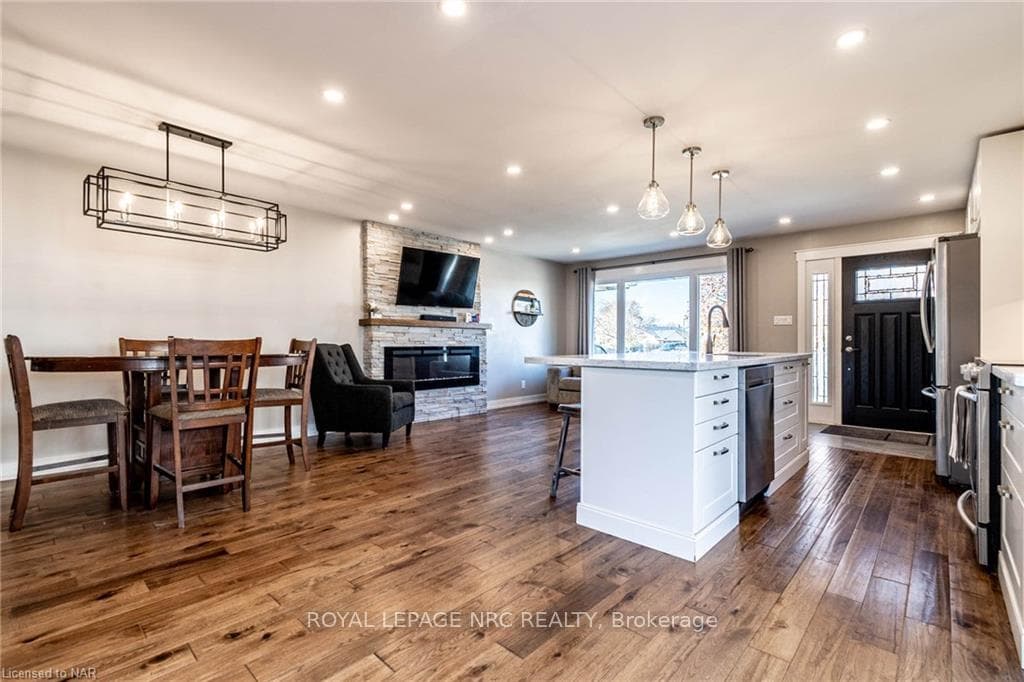 Kitchen with white cabinetry, hardwood / wood-styl