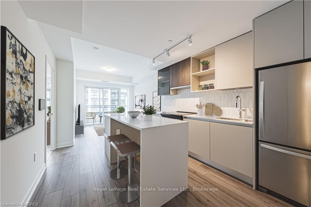 Kitchen with a breakfast bar, sink, light hardwood