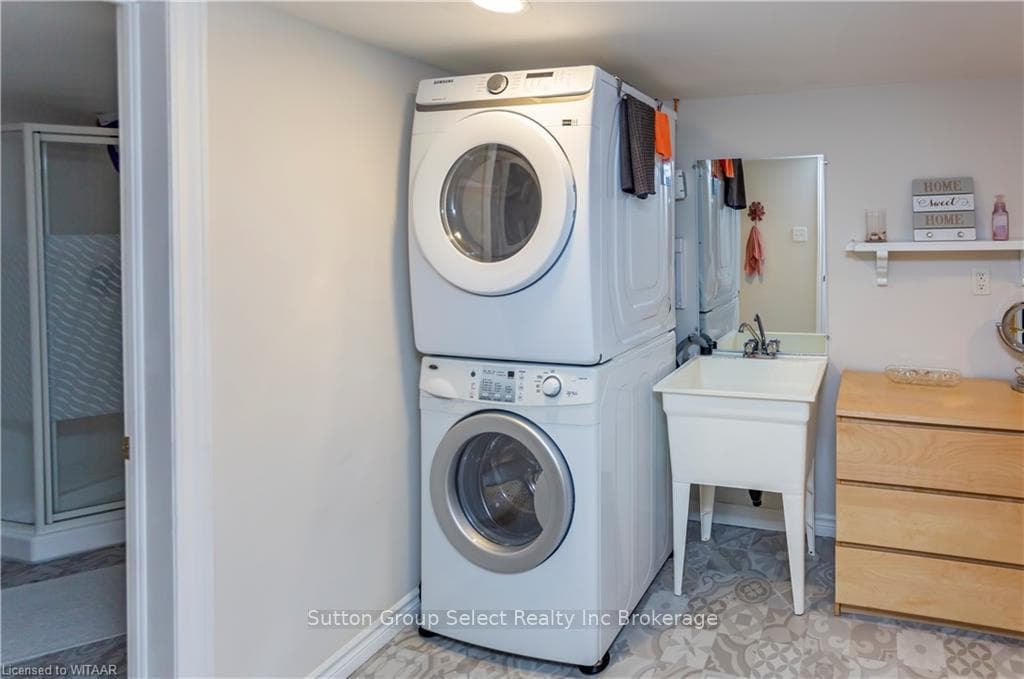 Washroom featuring stacked washing maching and dry