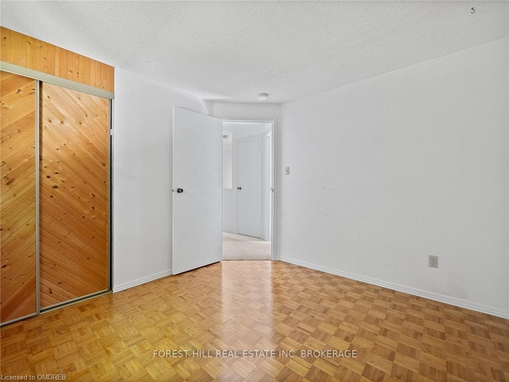 Spare room with a textured ceiling and light parqu