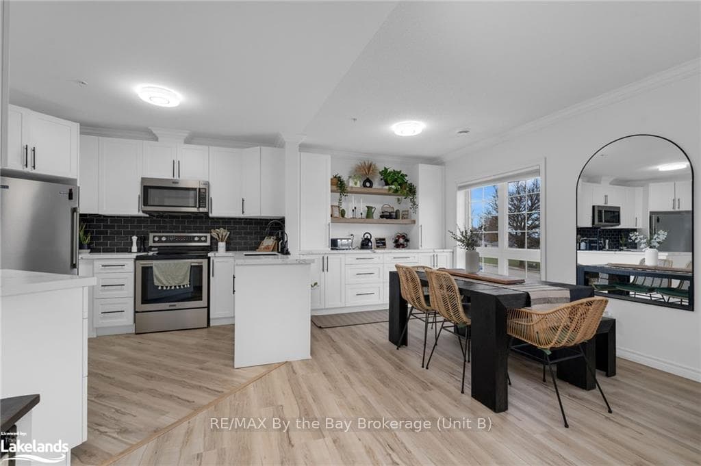 Kitchen featuring white cabinets, crown molding, d
