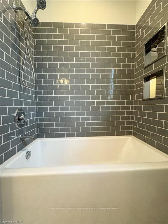 Bathroom tiled shower with tub.