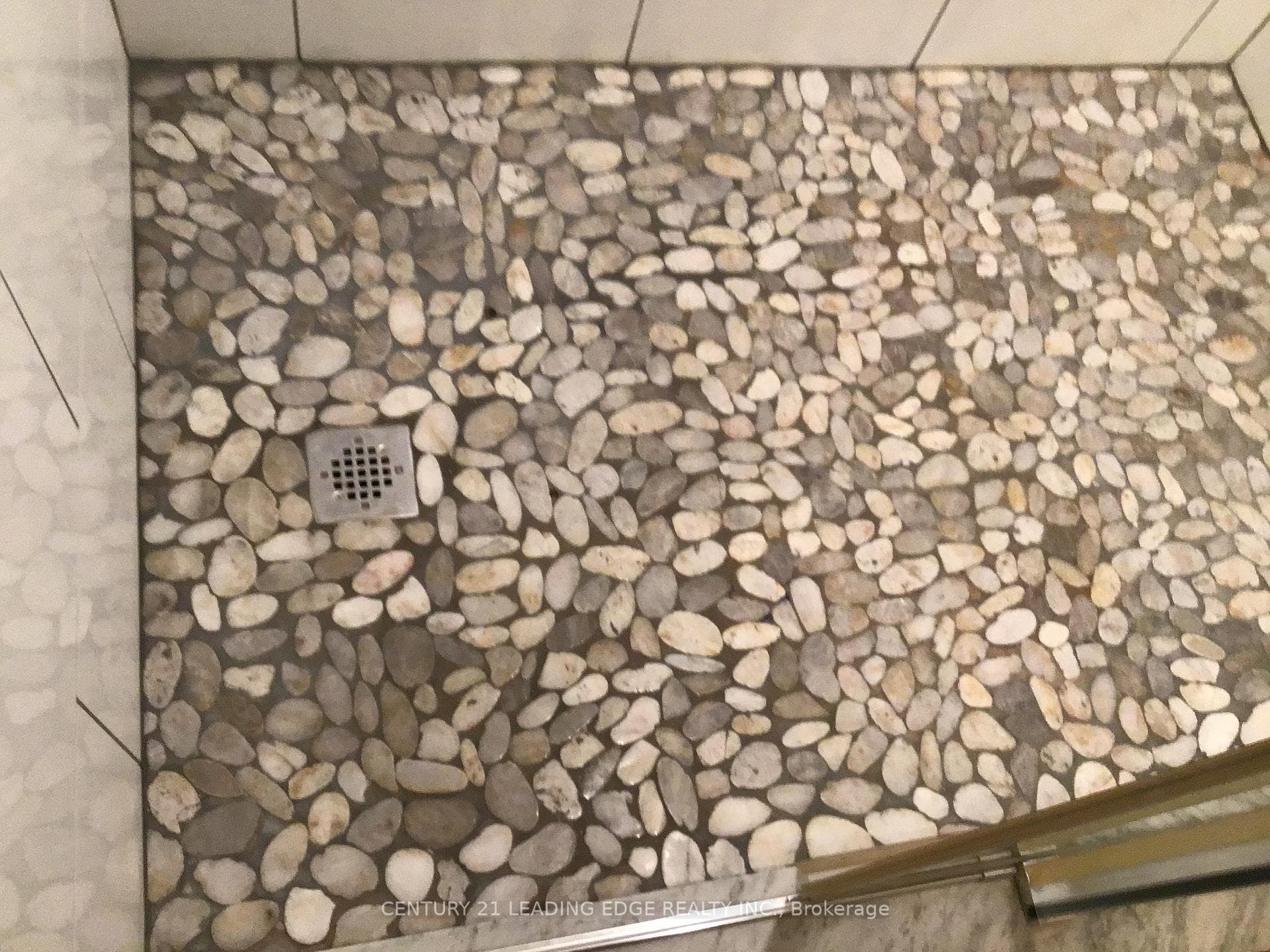 shower with pebble floor and glass sliding door