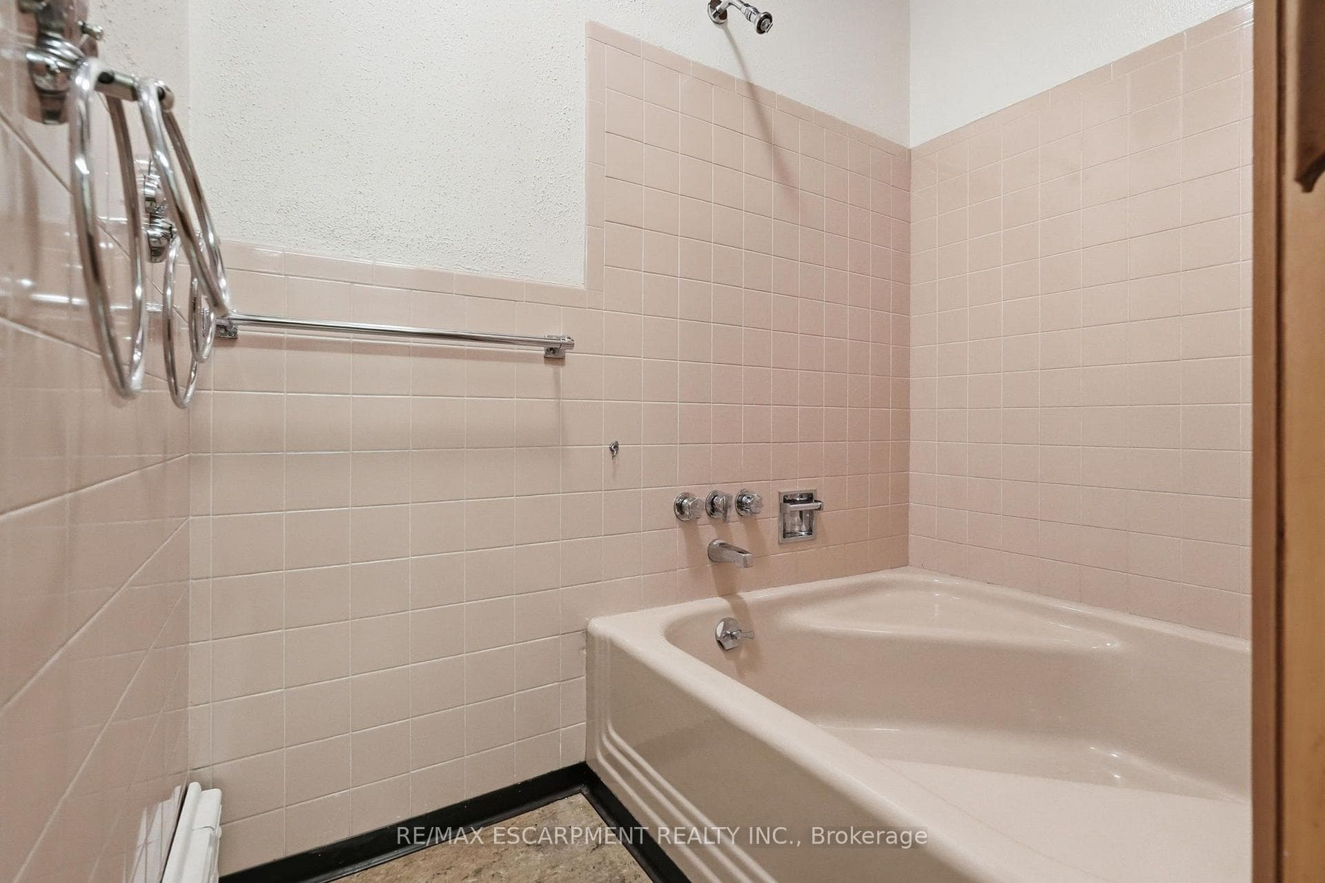Bathroom featuring light pink wall tiling