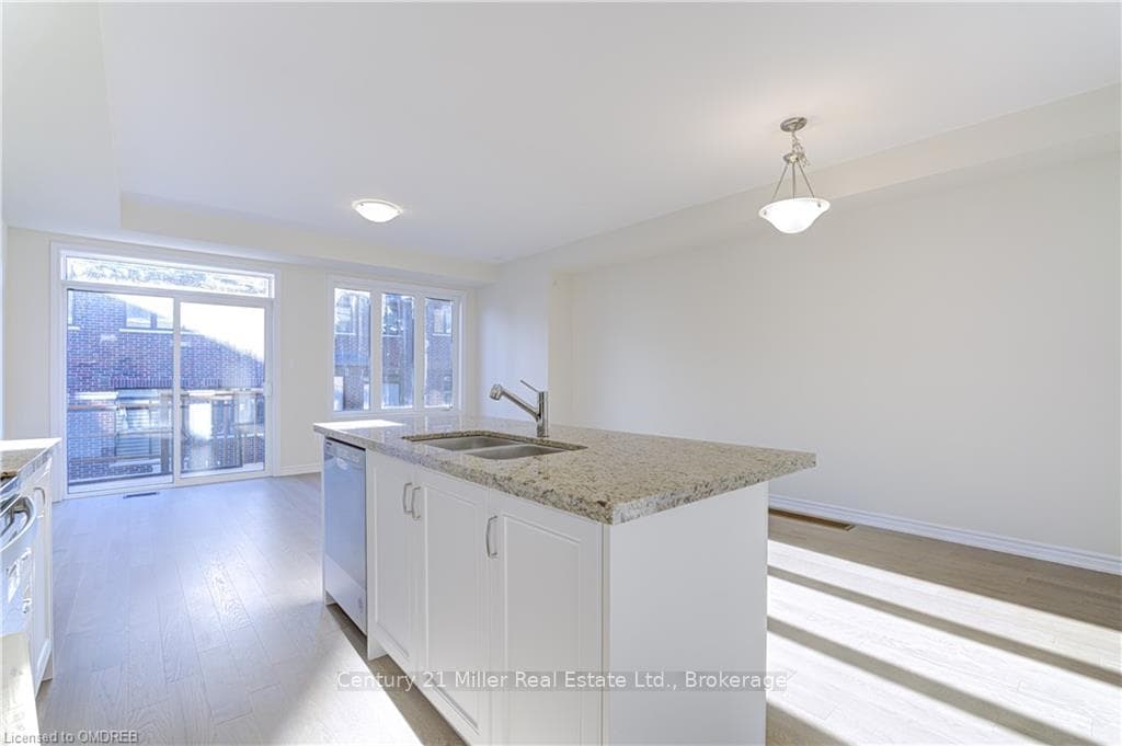 Kitchen with white cabinets, sink, an island with