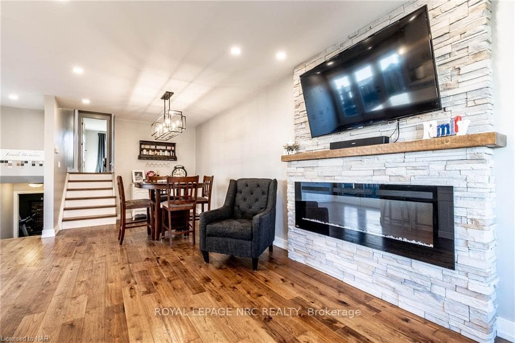 Living room featuring a stone fireplace, wood-type