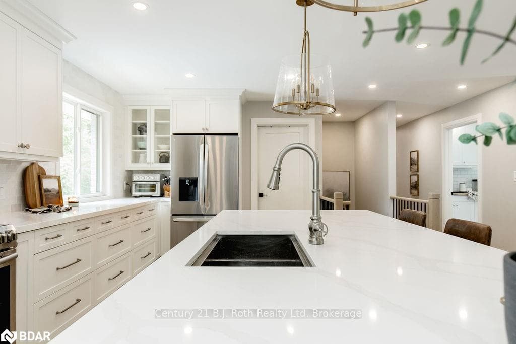 Kitchen featuring white cabinetry and stainless st
