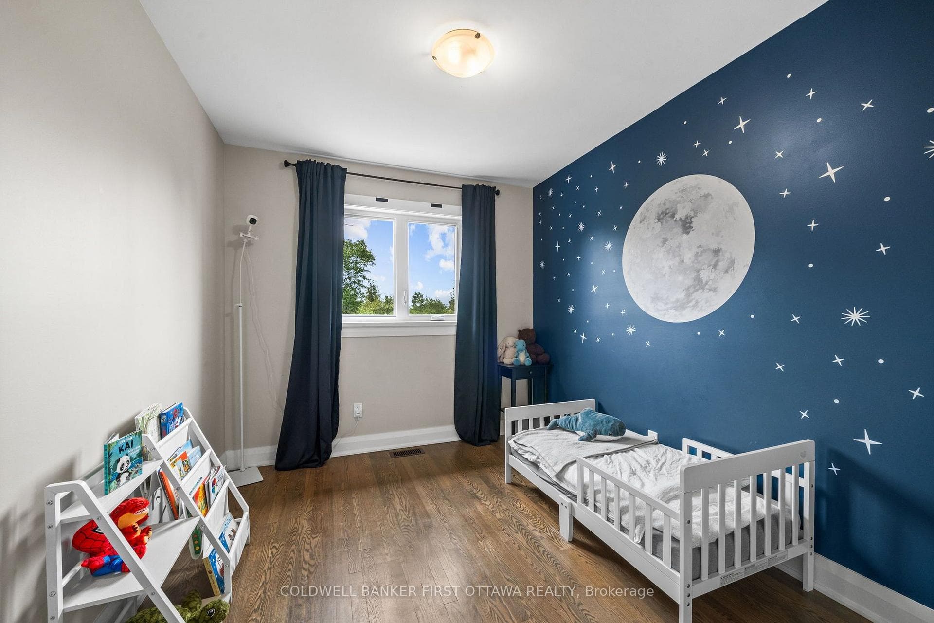 Bedroom w bright window & fixture above.