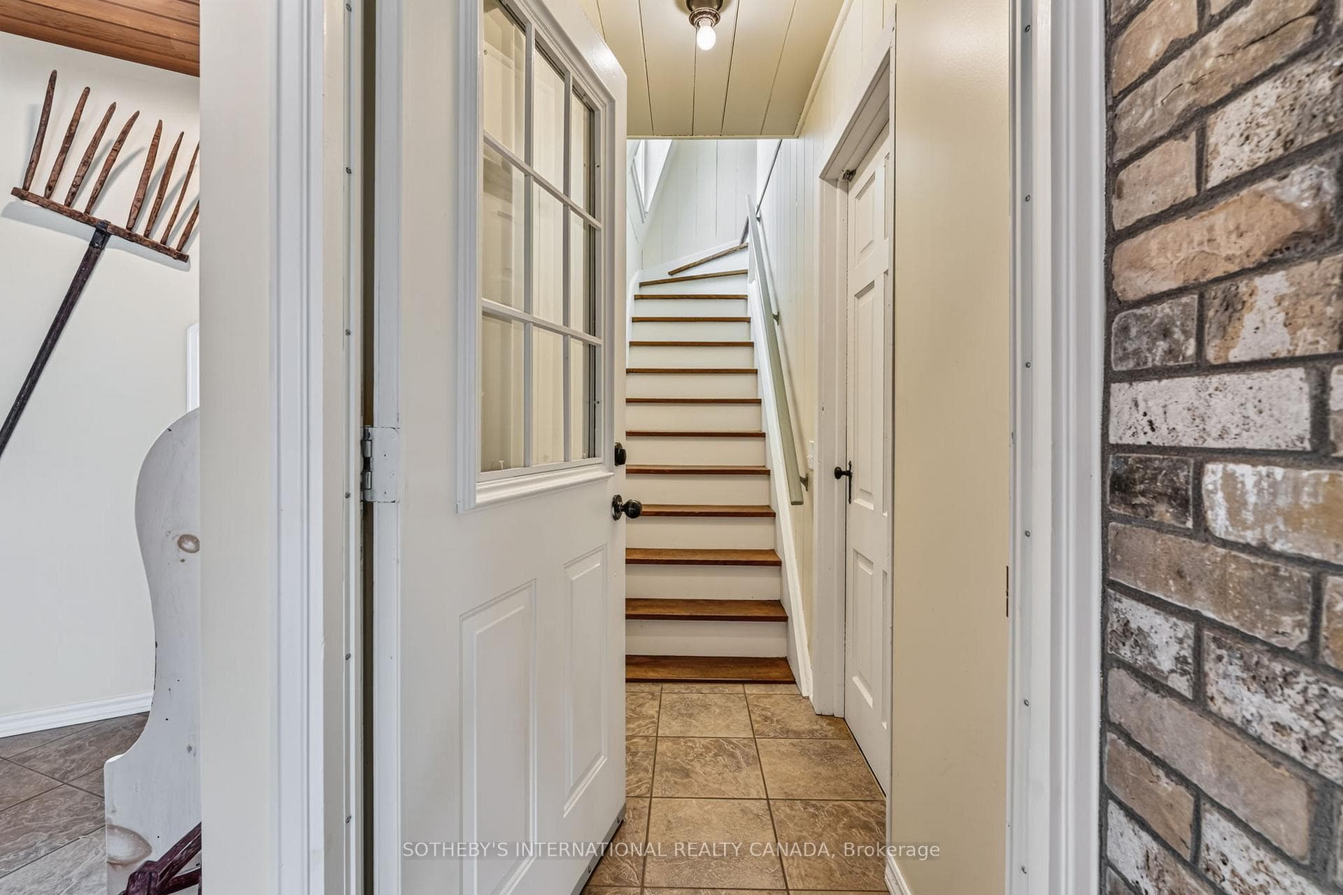 Stairwell to seasonal space. Entry to garage.