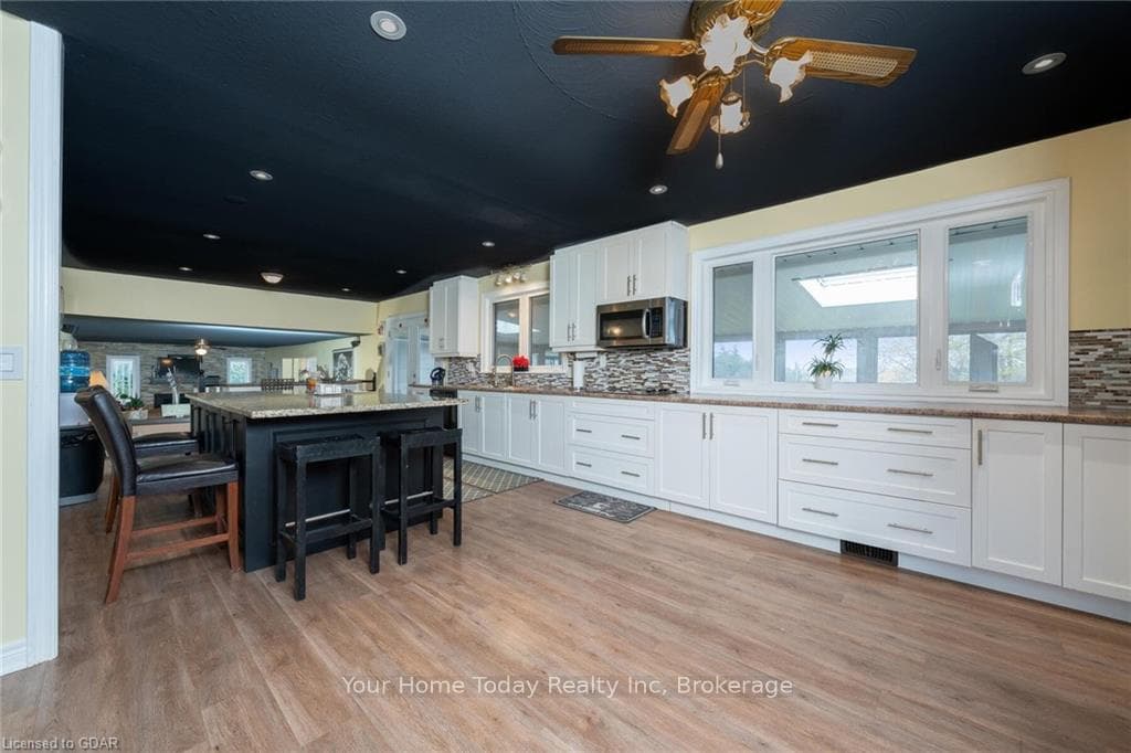 Kitchen with white cabinets, a center island, ligh