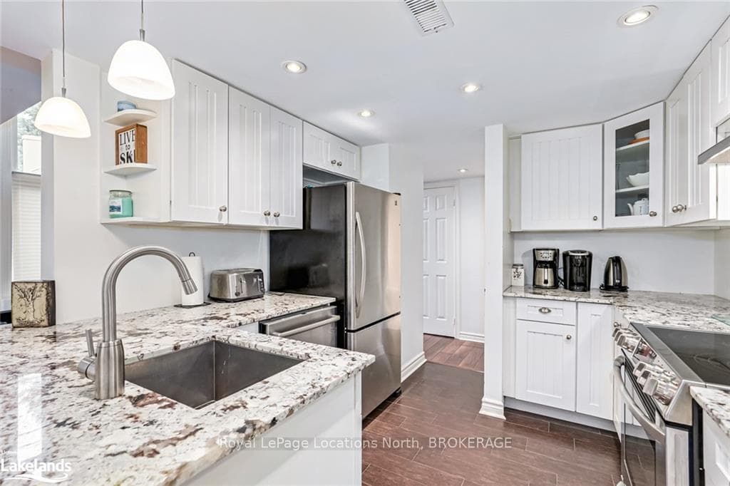 Kitchen with white cabinetry, hanging light fixtur