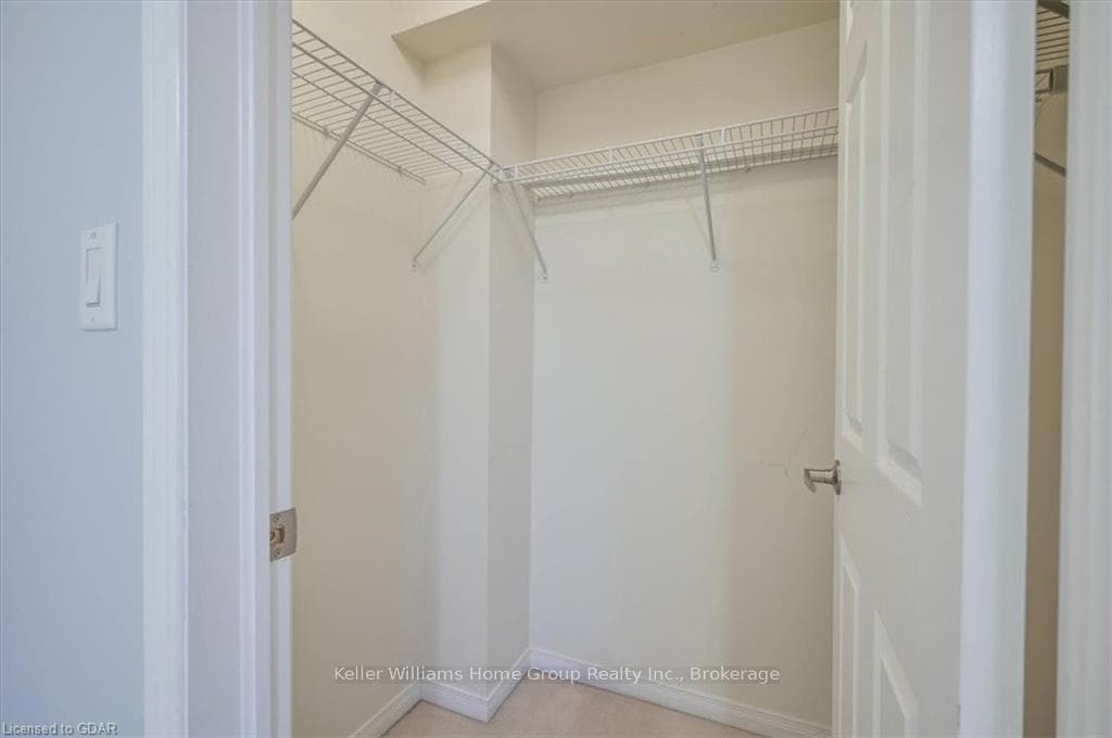 Walk in closet featuring light colored carpet