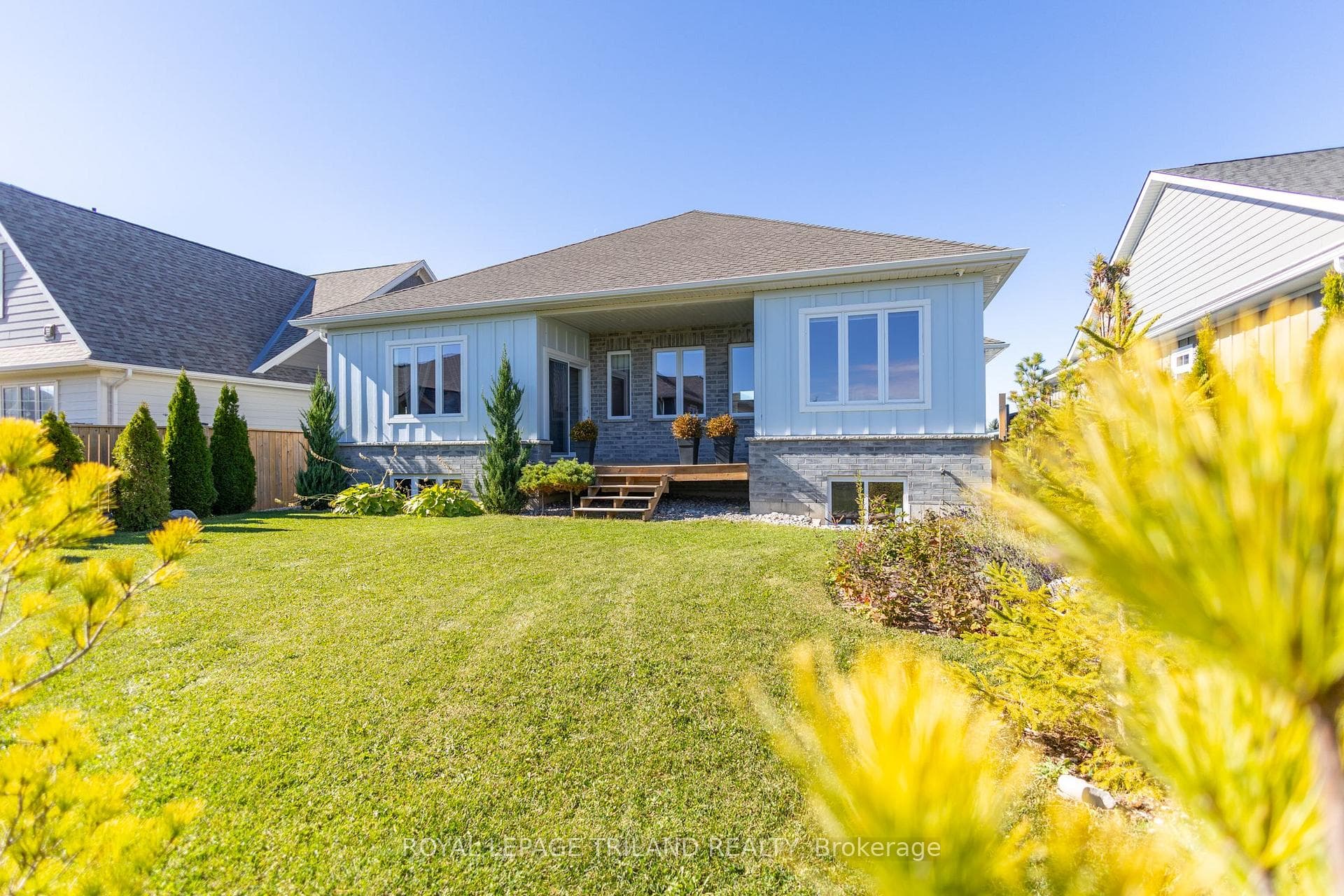 Covered deck overlooking well landscaped backyard